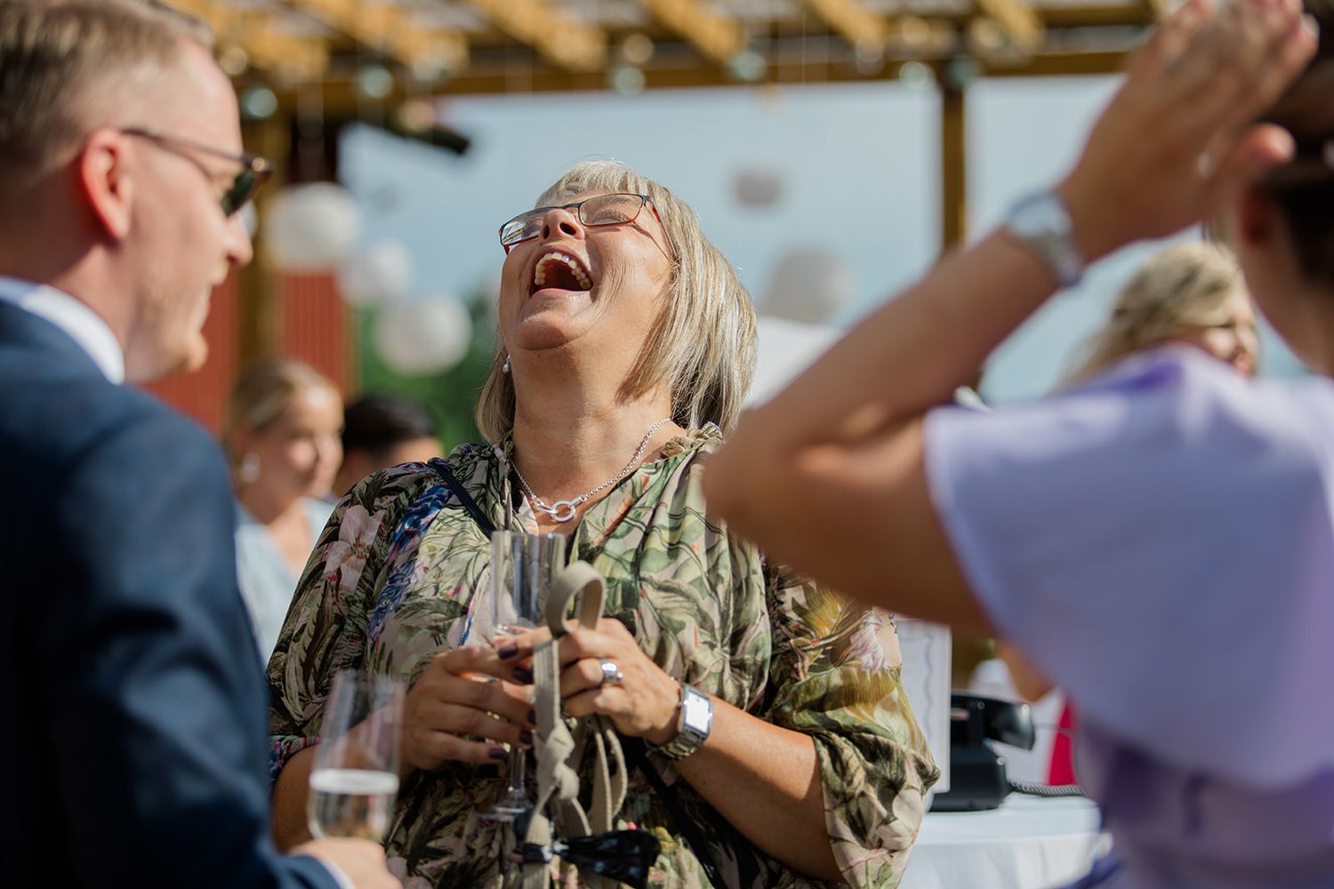 A group of people laugh joyfully while sitting together at a social gathering.