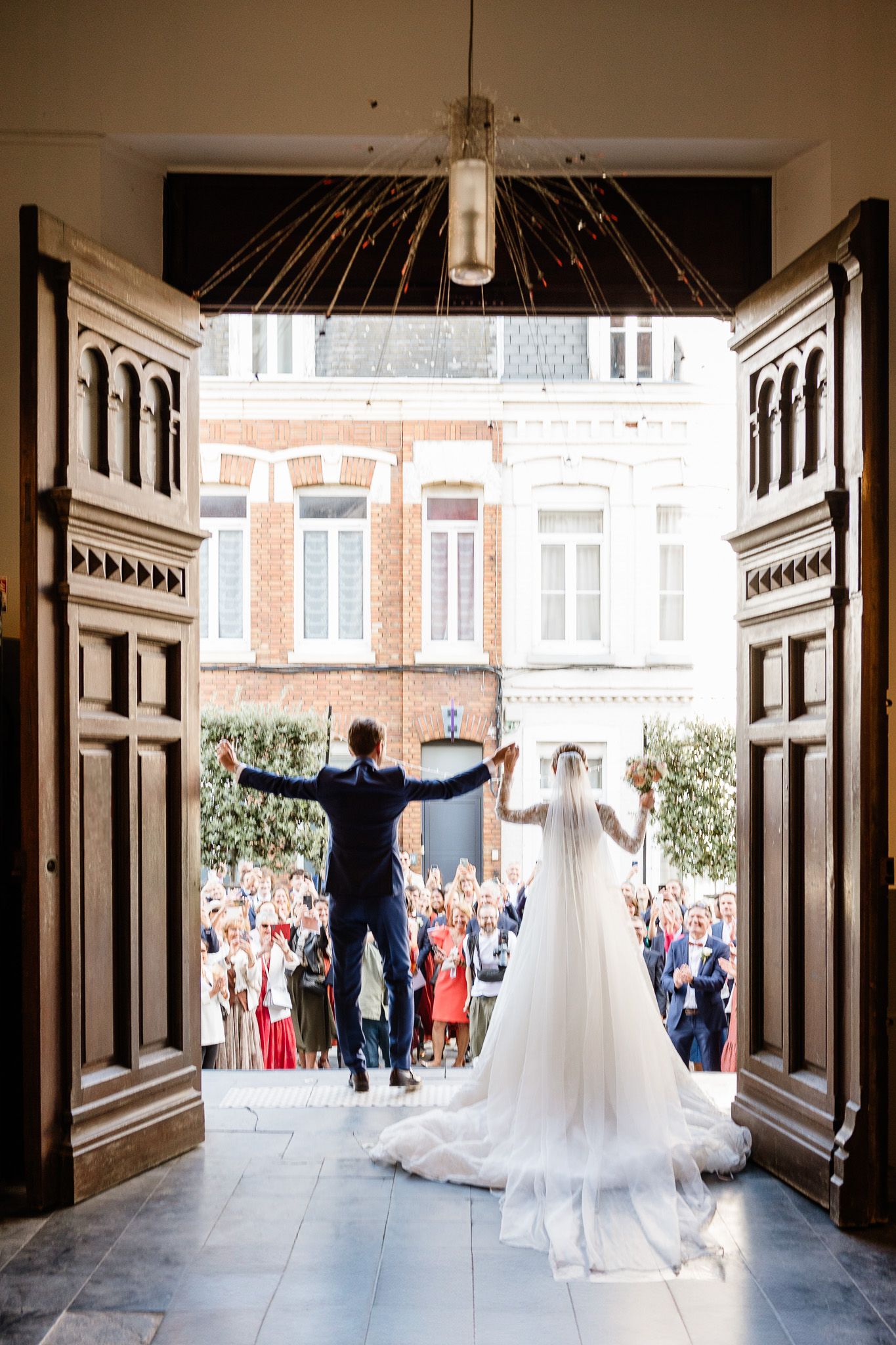 Sortie des maries apres la ceremonie religieuse a l'eglise sainte calixte de Lambersart capture par un photographe de mariage professionnel