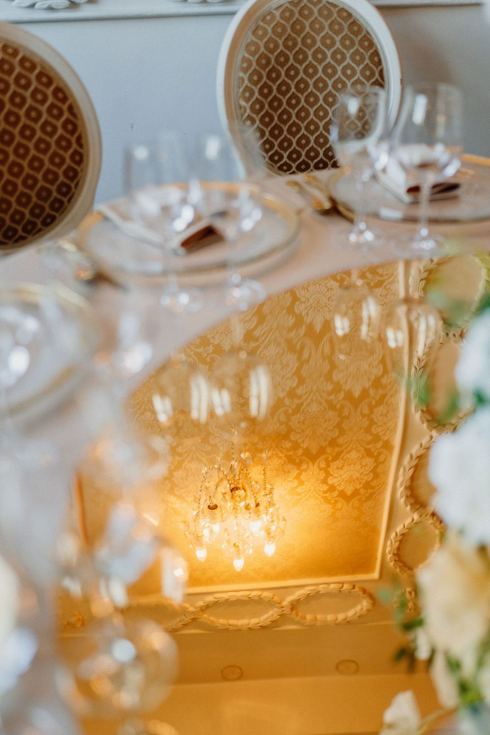Crystal glassware and elegant table settings create a warm, romantic ambiance at an upscale dining event.