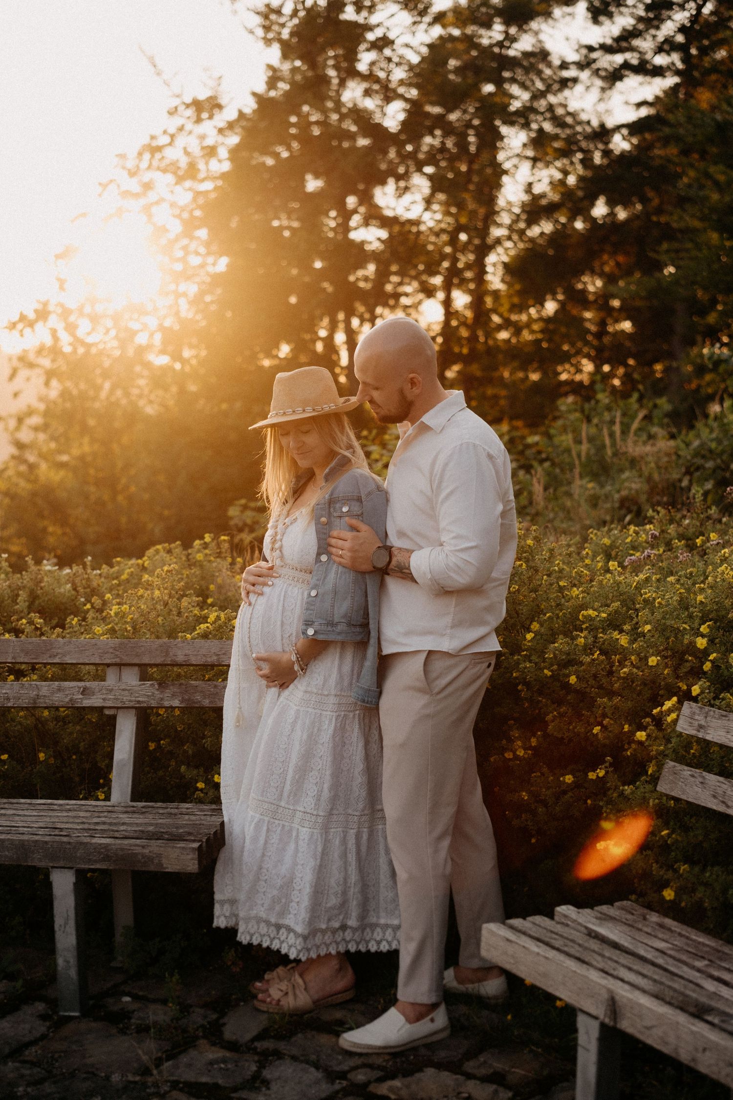 A romantic sunset photoshoot on rustic wooden benches surrounded by wildflowers.