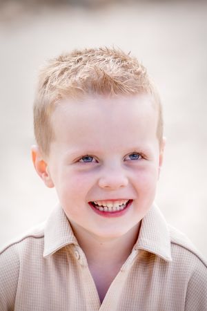 portret van een lachend, blond jongetje