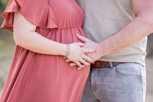 zwangere buik, waarbij man en vrouw hun handen op de buik leggen