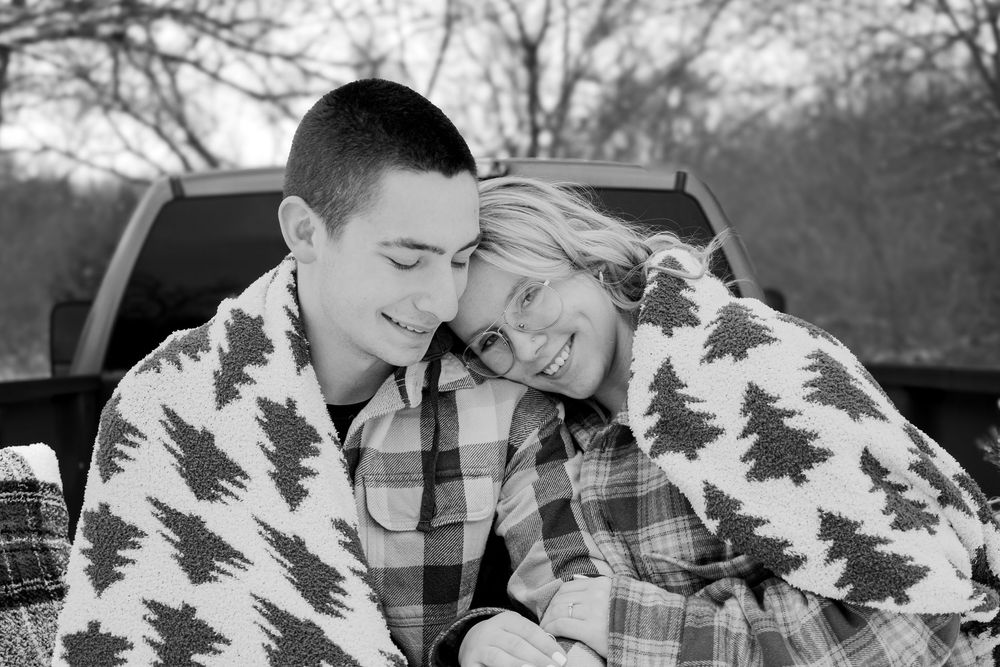 Black and white intimate portrait of a couple wrapped in blankets during an outdoor lifestyle session in Michigan