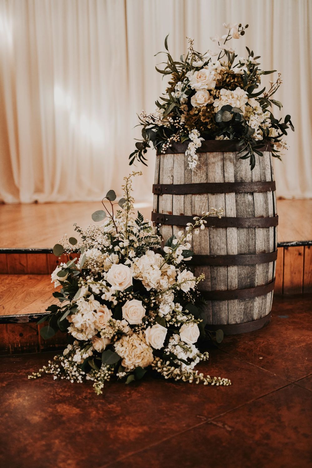 Long farmhouse tables lined with glass votives, loose greenery runners, and chic olive-green place settings.