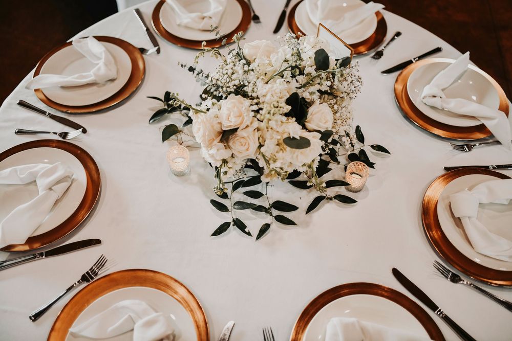 loose greenery and ivory floral centerpieces of a reception table at a denton wedding venue