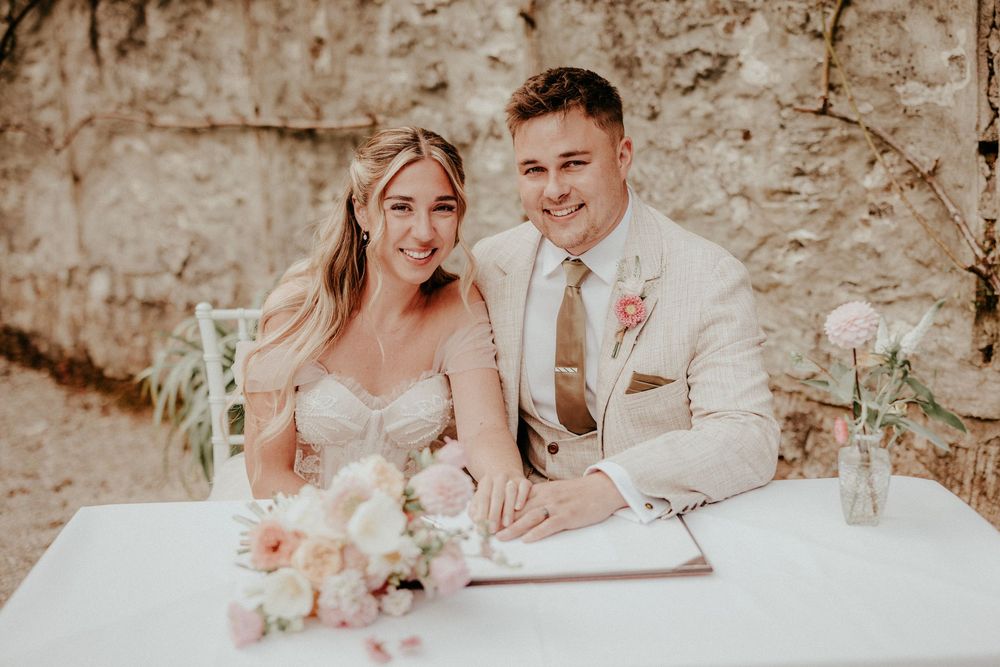 A bride and groom share intimate moments in a rustic stone setting during their wedding celebration. Cornwall wedding photographer