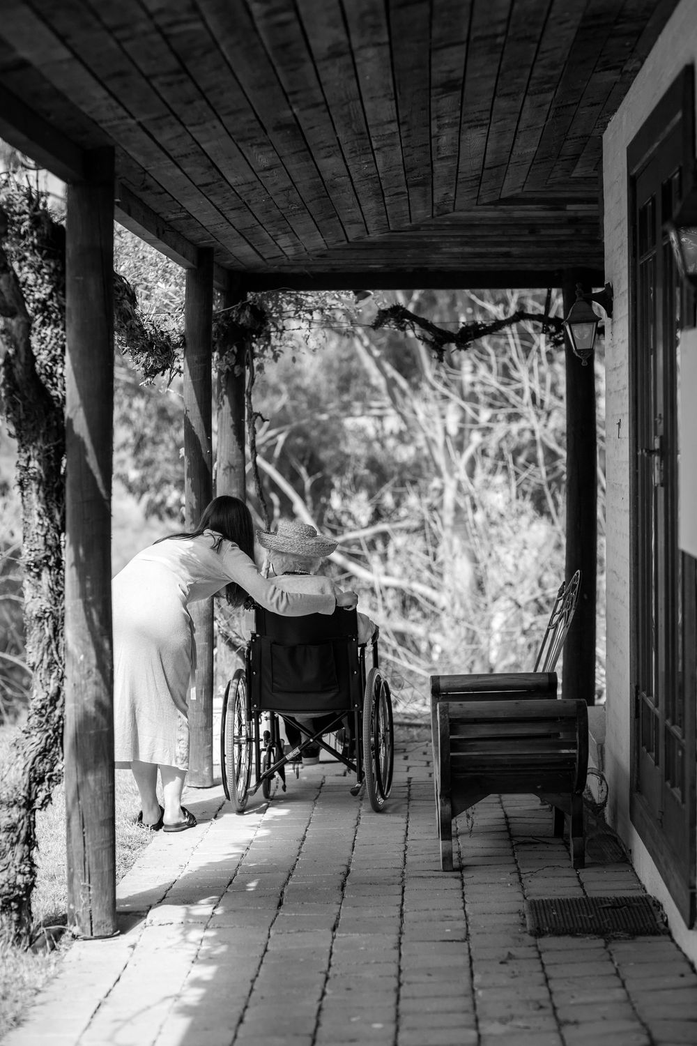 A series of black and white photographs showing a covered walkway with stone pillars and wooden beams casting dramatic shadows.