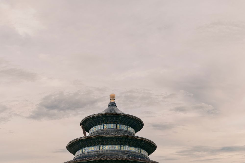Temple of Heaven pagoda top rising against cloudy sky in Beijing, China.
