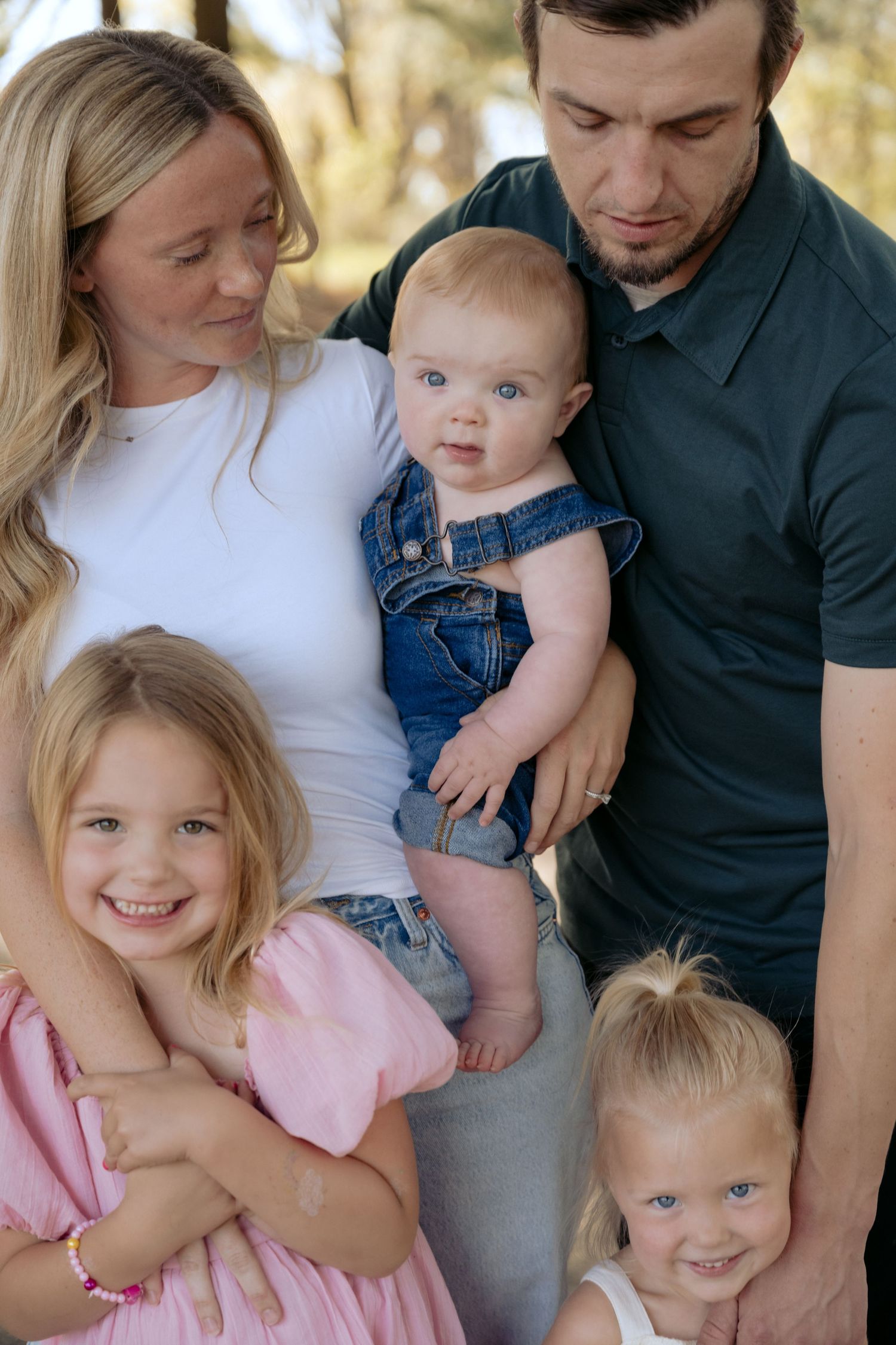 Closeup of family of five with three toddlers during their lifestyle outdoor spring session at a WI park.