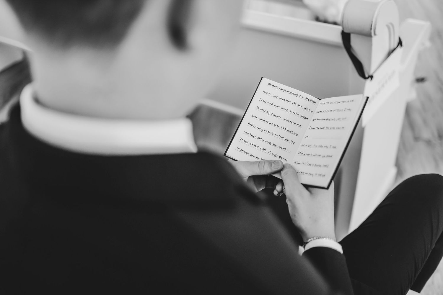 Groom sitting in natural light inside the white chapel before the ceremony