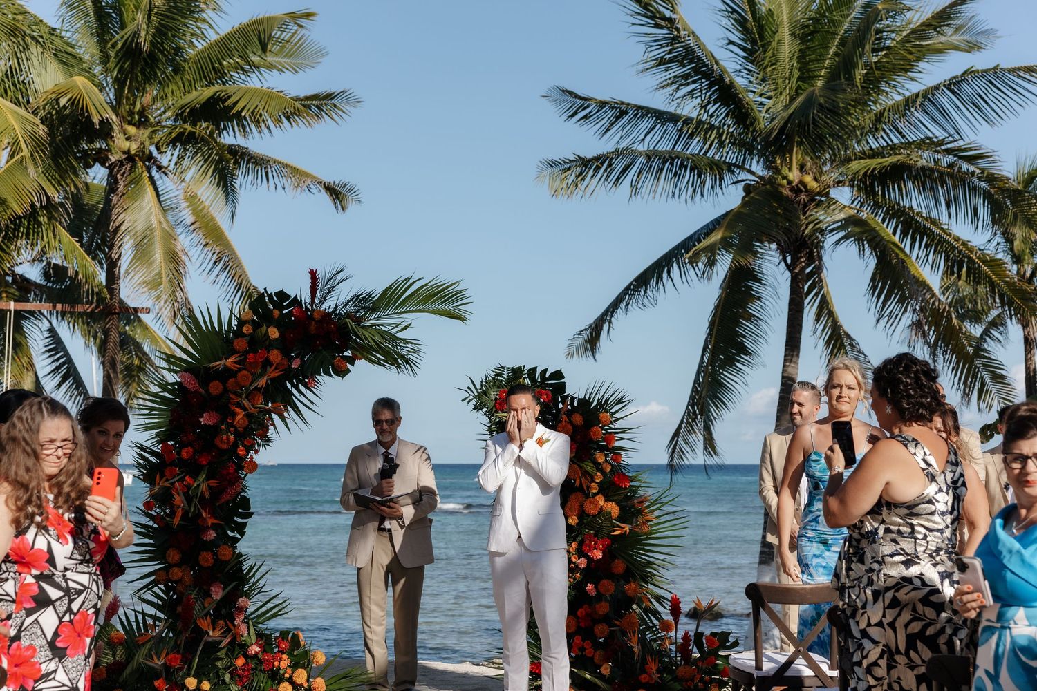 Groom's reaction to bride walking down the aisle at their wedding in Blue Venas Paa Mul