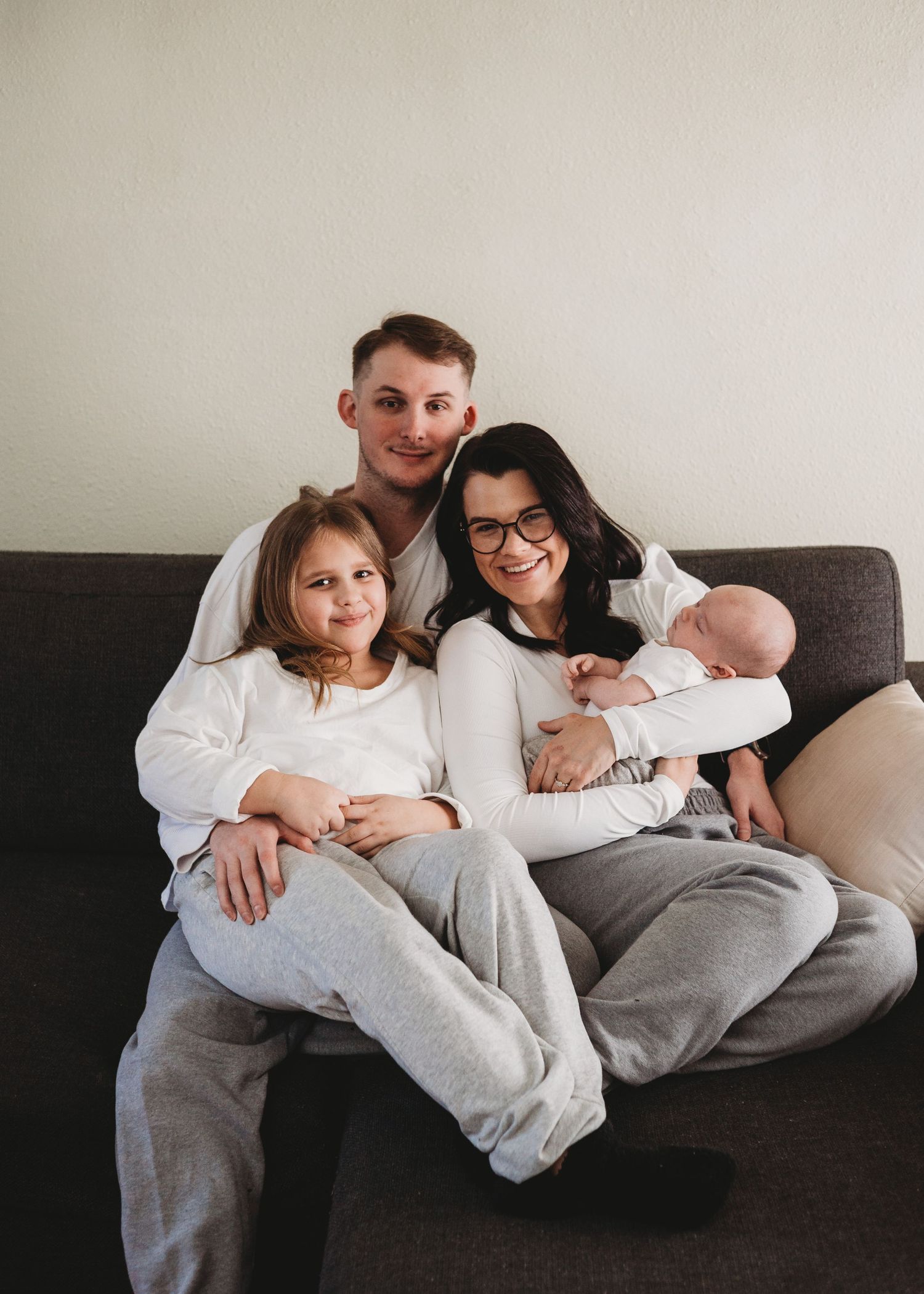 Family cuddling together on a couch at home during a family photography session