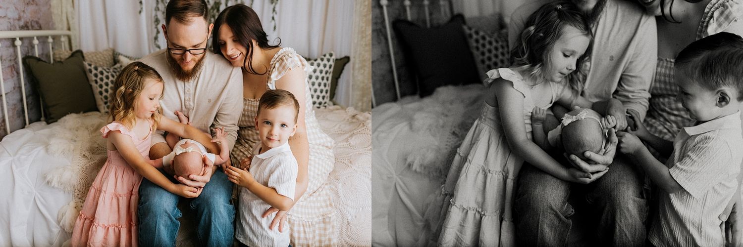 A family with two young girls and parents tenderly holding a newborn baby during a soft, warm lifestyle newborn photography session.