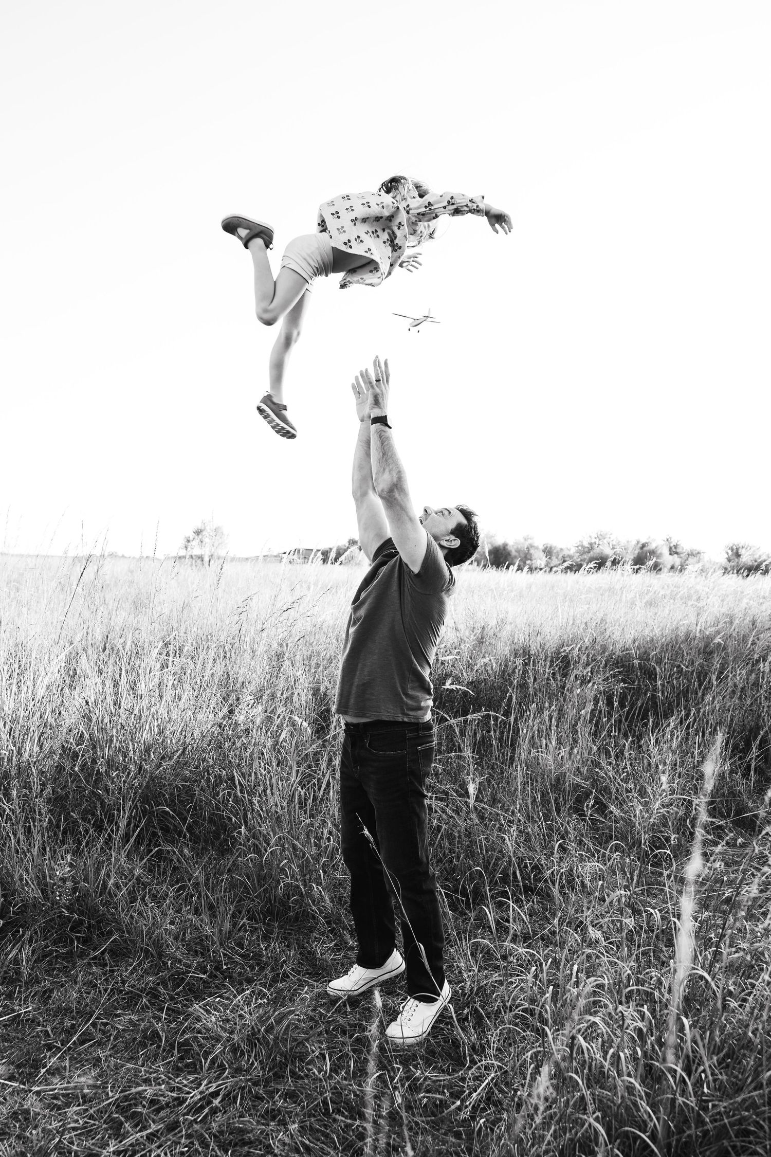 A sequence of black and white photos shows someone jumping and doing backflips in a grassy meadow.