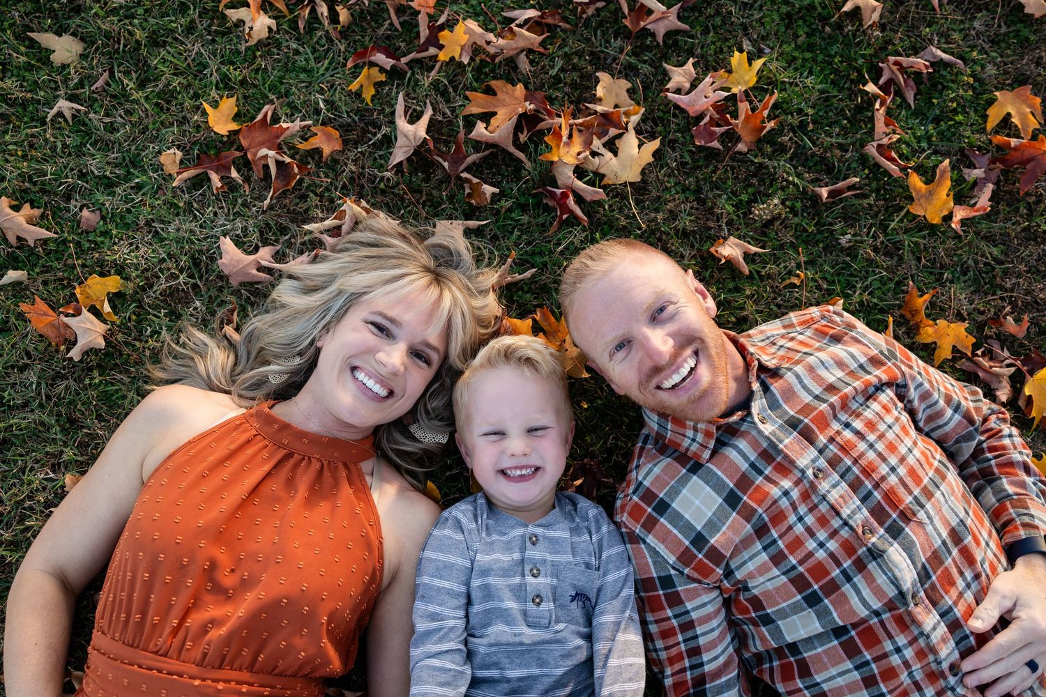 A series of autumn-themed outdoor photos with people laying in fallen orange and brown maple leaves.