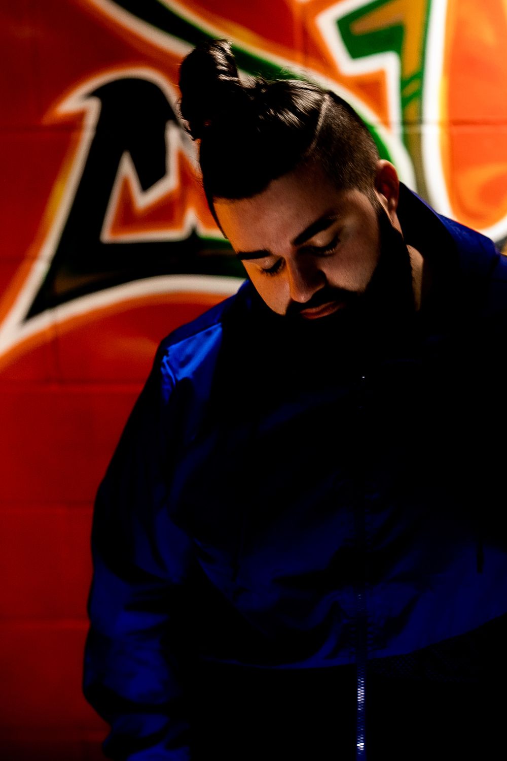 Silhouetted figure in blue against orange background in low light conditions.