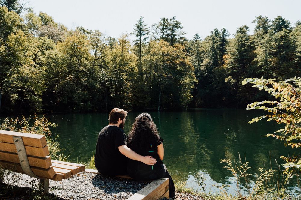 Couple sitting together on a wooden dock overlooking fuller lake in central pa