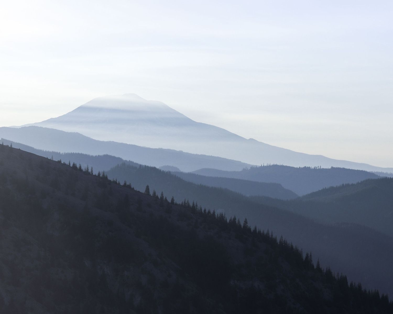 Photograph of layers of mountains in shades of blue.