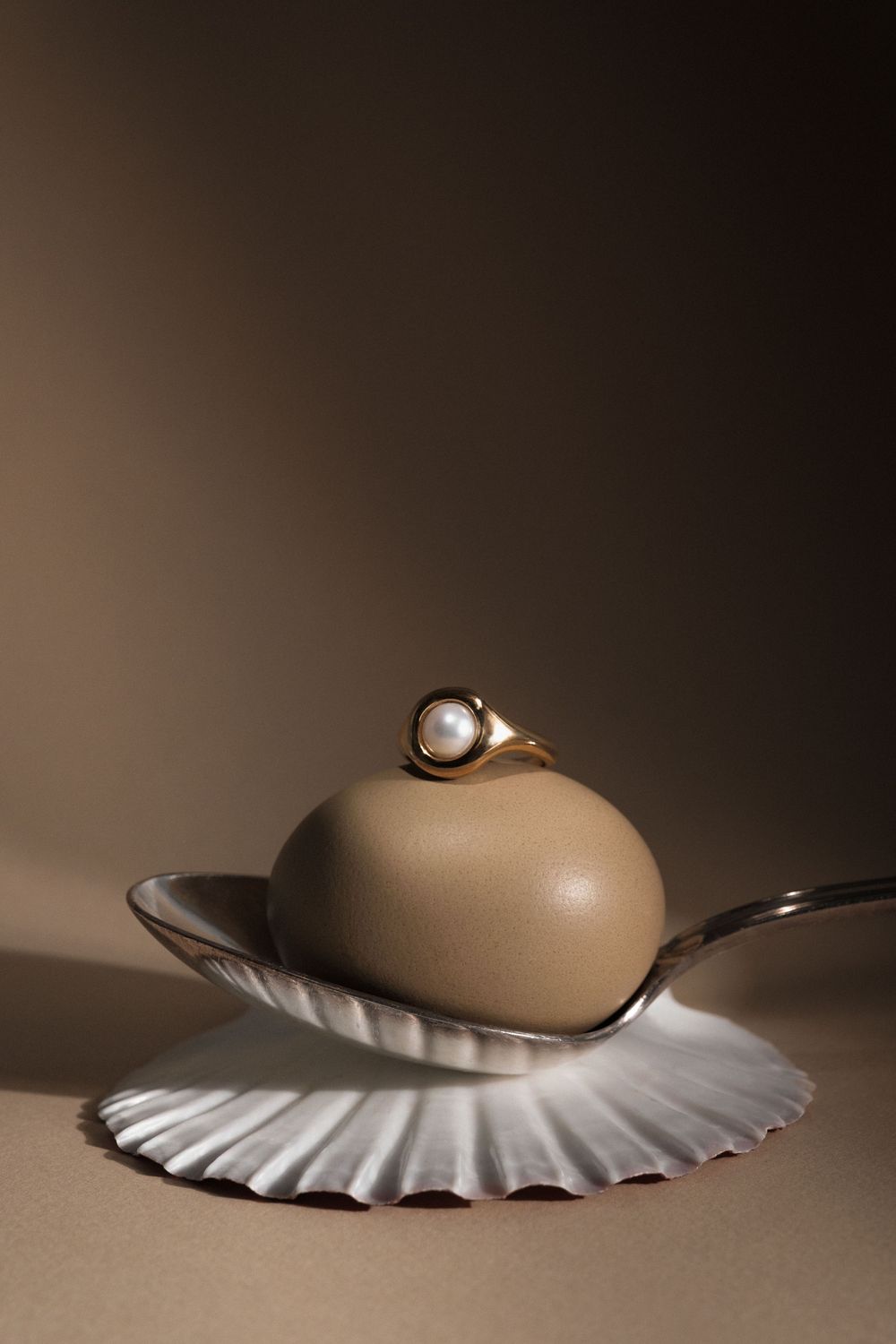 A minimalist still life series showing a round ceramic vase casting dramatic shadows on a ruffled white surface.