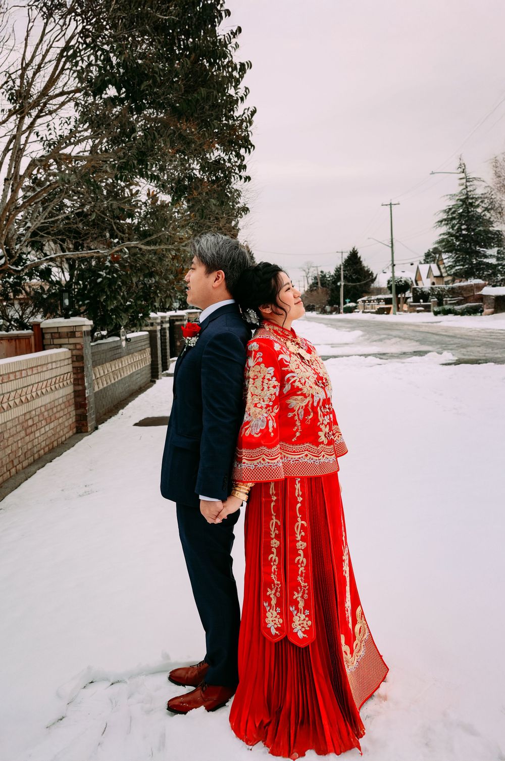 traditional chinese wedding photo on a snowy street, with the bride wearing a vibrant red dress. smilein wedding photography vancouver