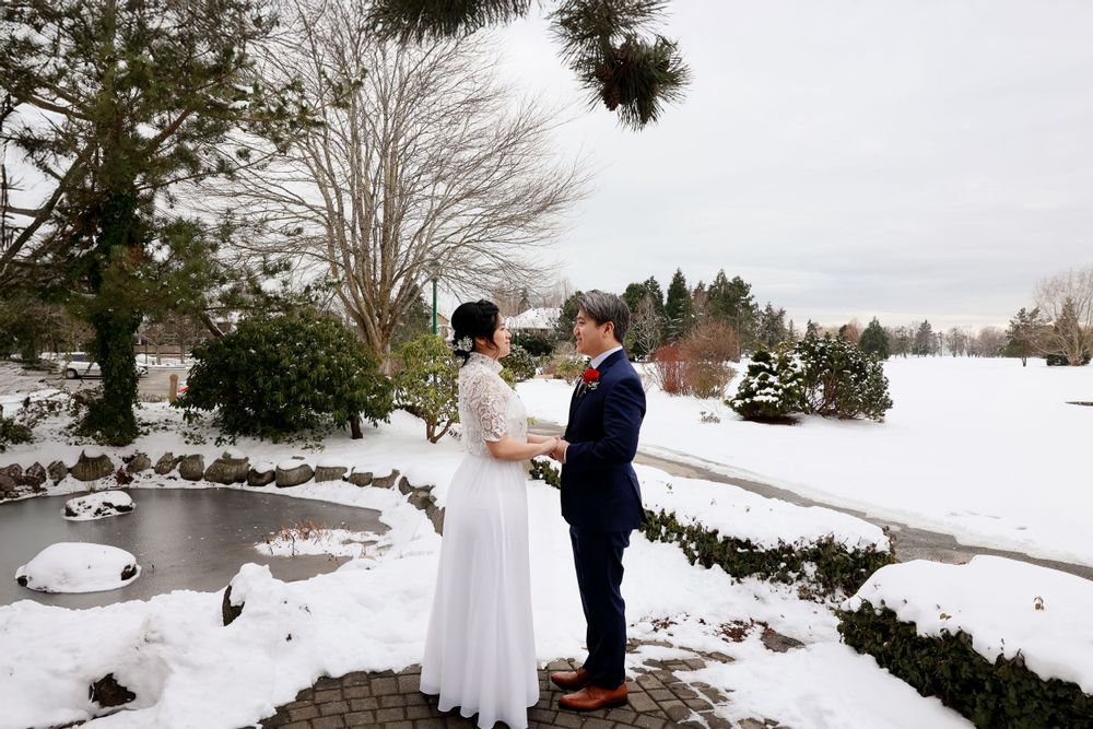 winter wedding ceremony beside a snowy pond with evergreen trees. smilein wedding photography vancouver