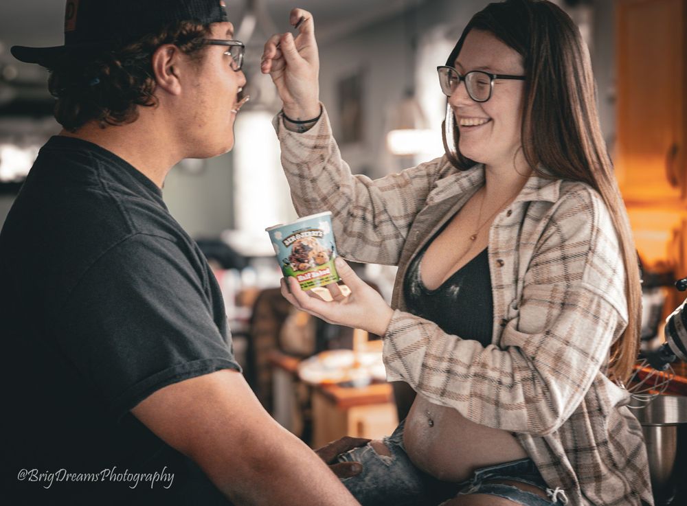 A tender moment between two people at home sharing a snack, with warm lighting and a cozy atmosphere.