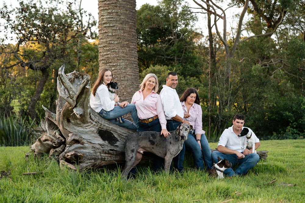 A stunning portrait of a family with their four dog at a lovely green property in the central coast