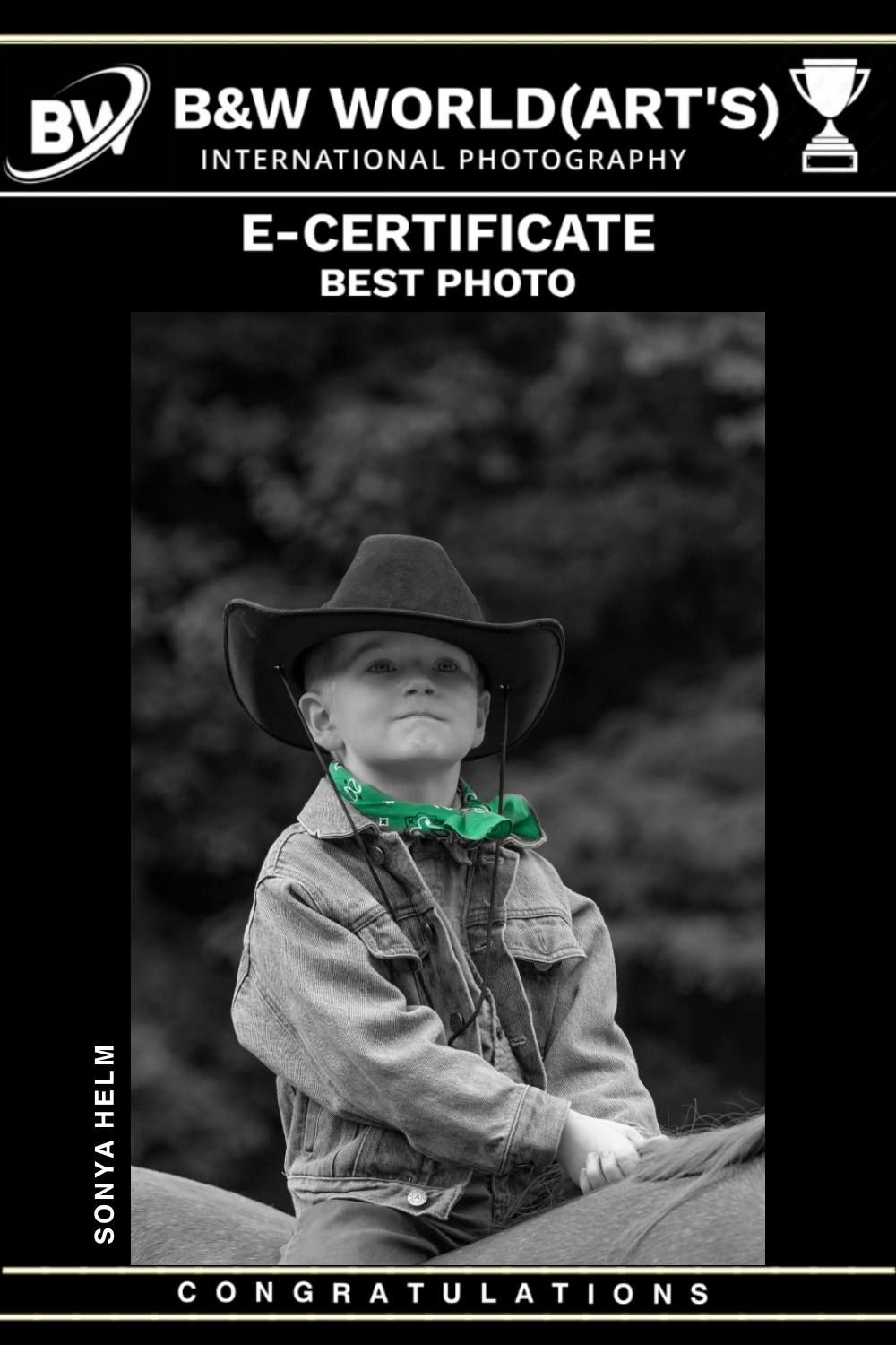 Black and white portrait photograph of a young rancher in cowboy hat and denim jacket with green bandana.