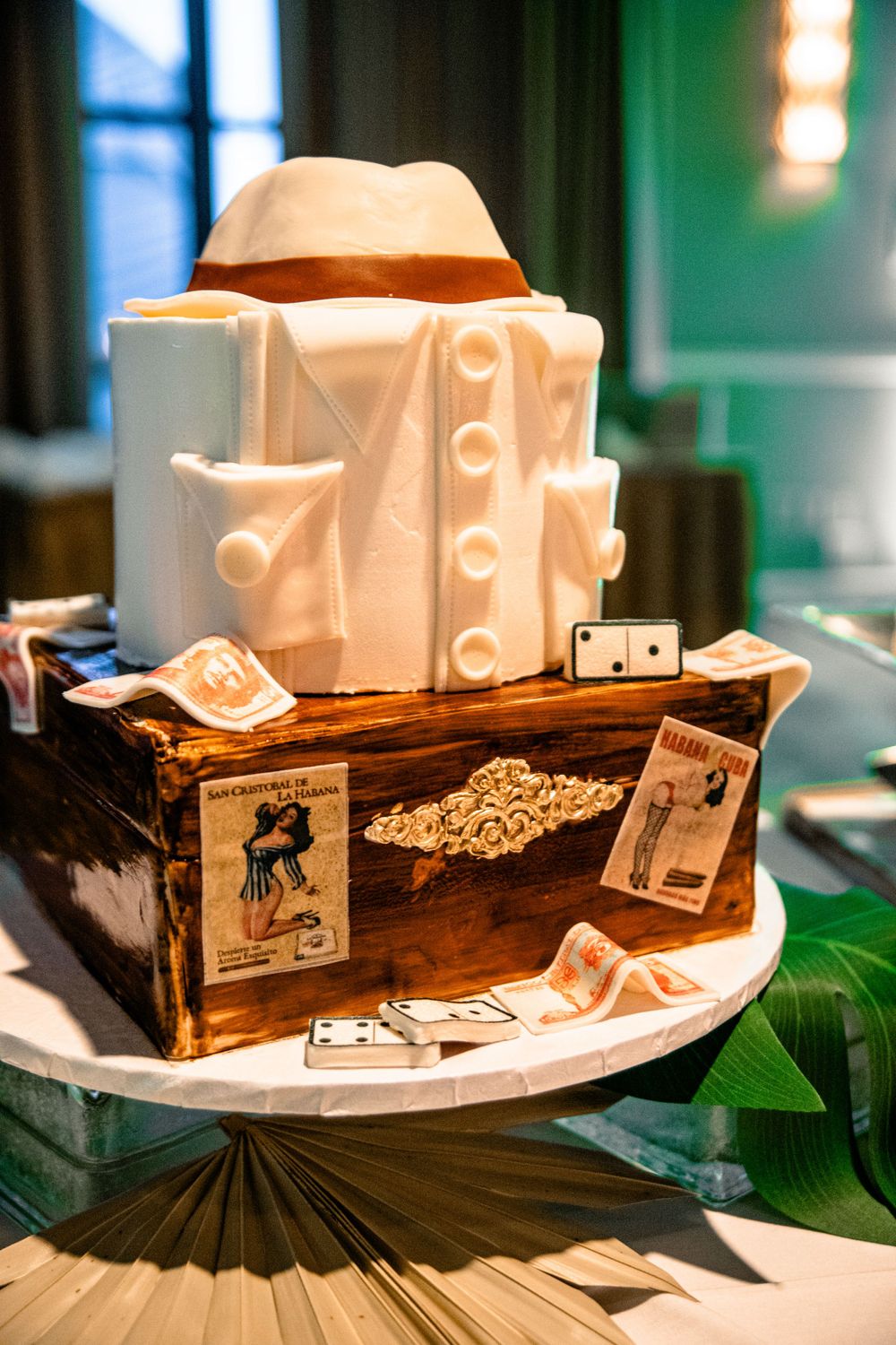 Decorative white ceramic faces displayed in wooden boxes with tropical leaves.