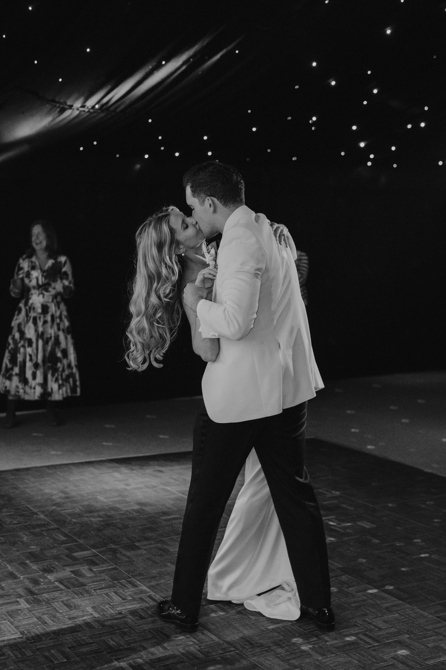 bride and groom kissing during their first dance surrounded by their wedding guests at hamswell house in bath