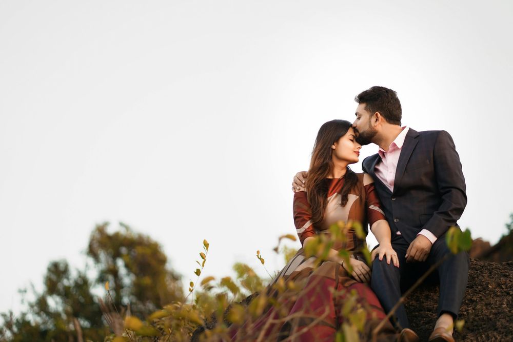 Romantic couple poses together during sunset photoshoot in natural outdoor setting.