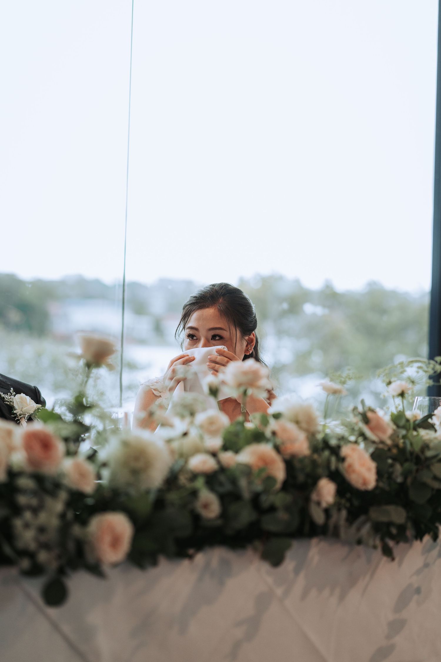 Elegant floral arrangements with peach roses decorate a wedding reception setting.