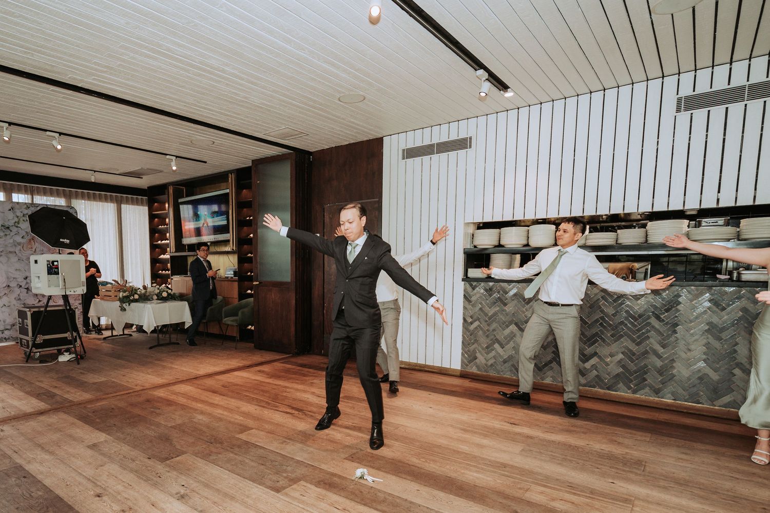 People dancing and having fun in an indoor venue with wood floors and modern decor.