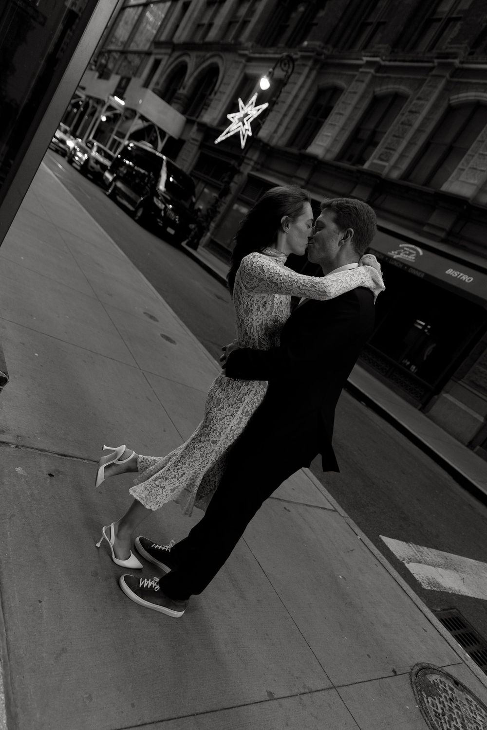 A sequence of black and white photos showing two people dancing together on a sidewalk at night.