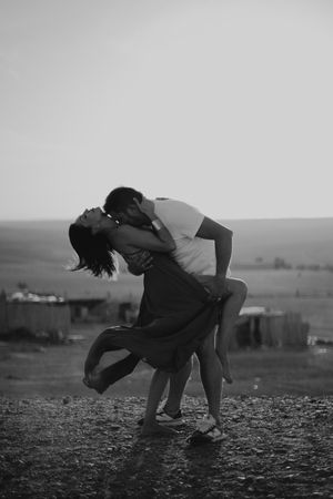 Dramatic black and white photo of couple dancing in rural setting.