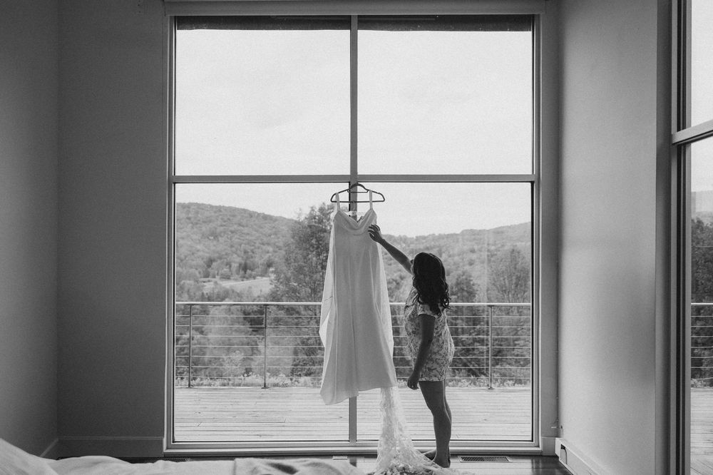 A black and white panoramic view through multiple windows showing a scenic mountain landscape and silhouetted figure.