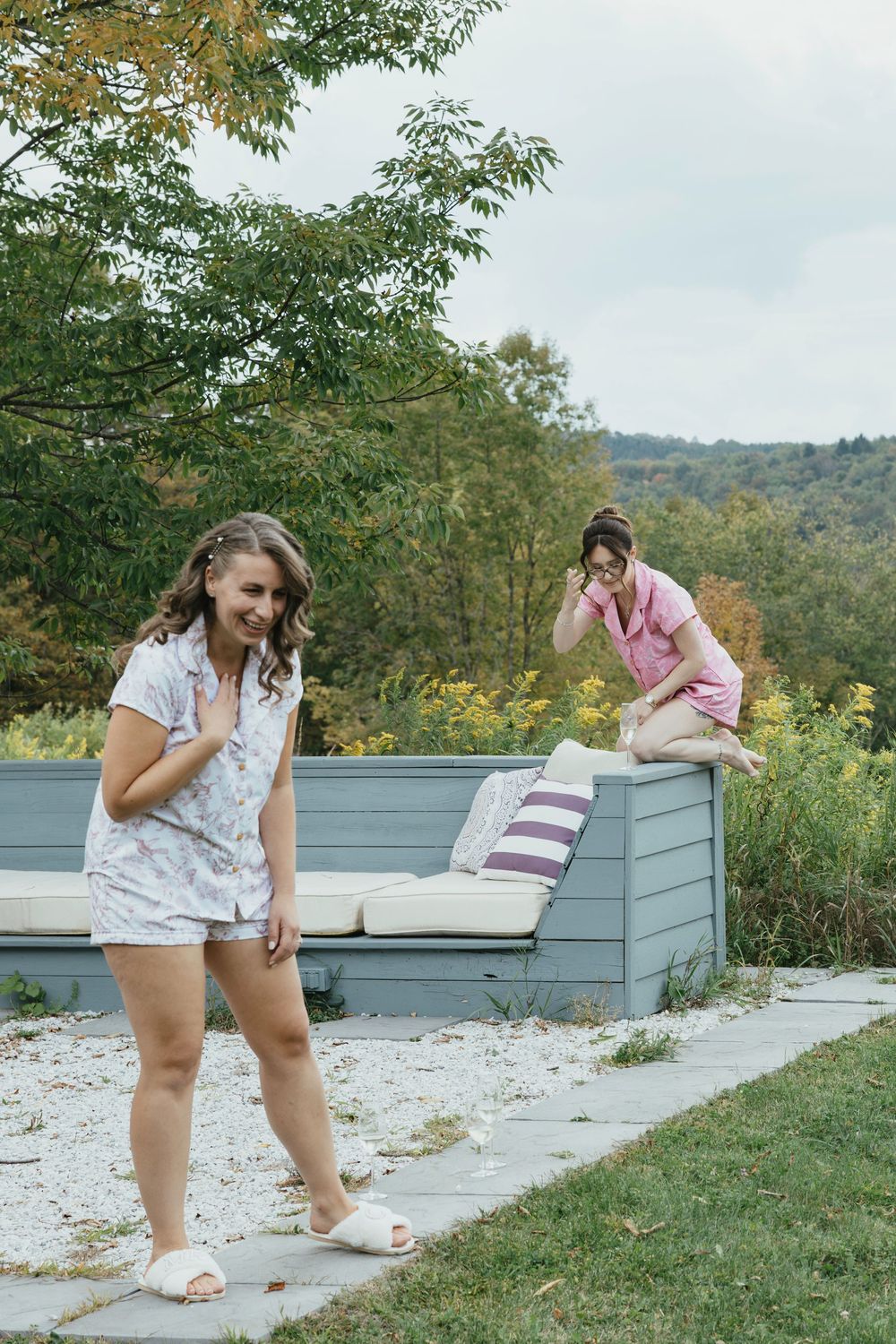A playful sequence of jumping and dancing movements on a grassy hillside overlooking a scenic landscape.