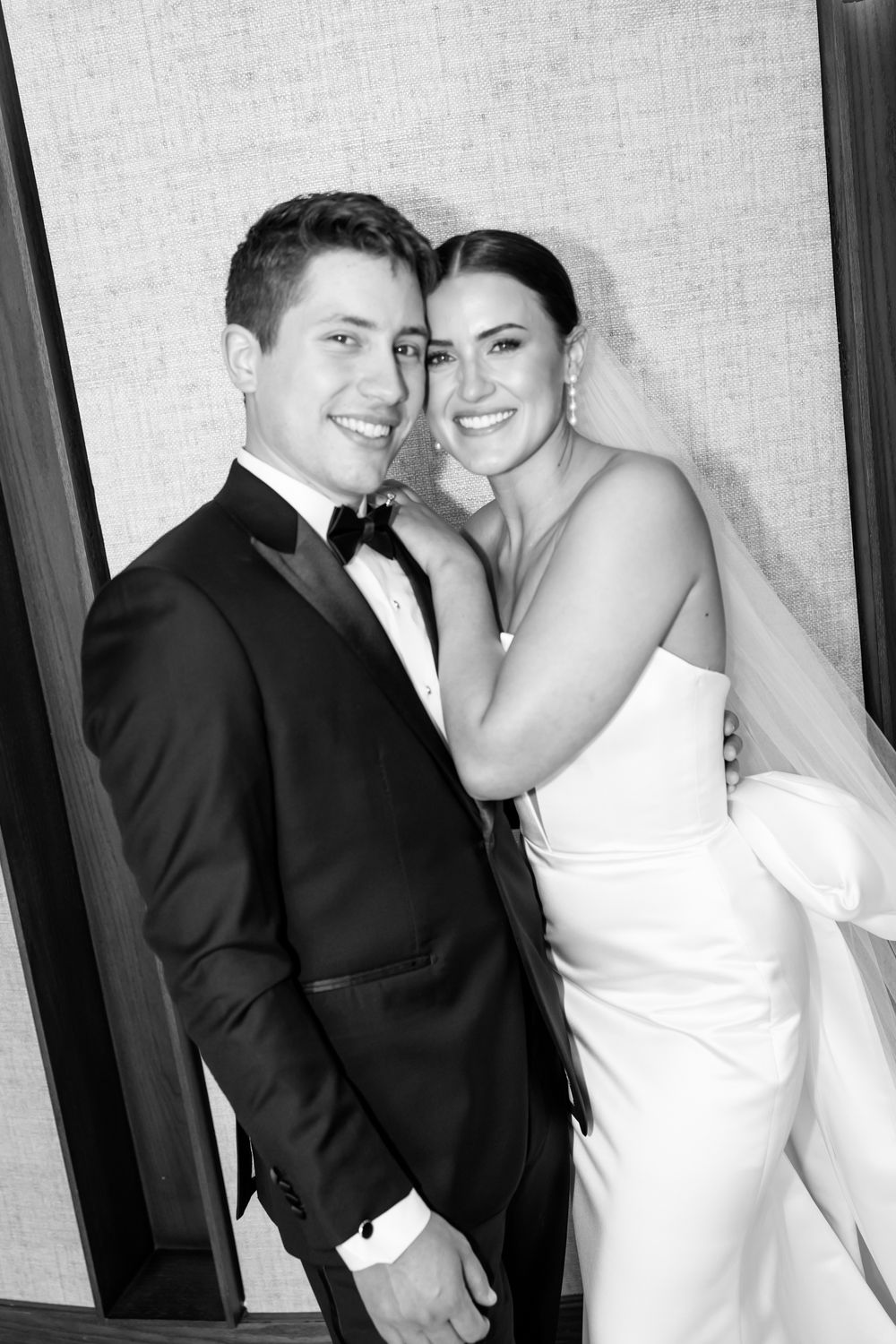 Happy bride and groom pose together in black and white portrait on their wedding day.