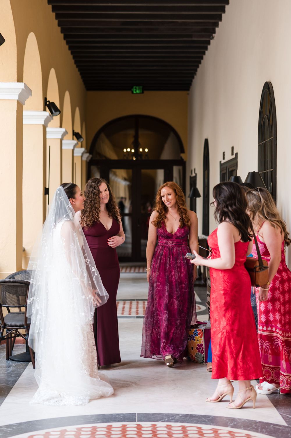 Bridesmaids adjusting veil for bride during wedding day at Hotel El Convento Puerto Rico