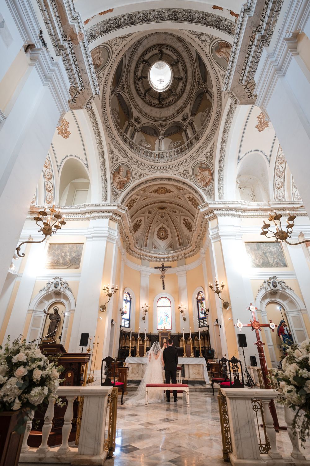 Interior architecture of San Juan Cathedral during wedding ceremony with ornate ceilings and altar