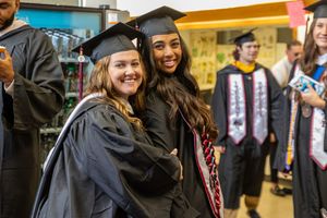 Students in graduation attire celebrate their academic achievement.