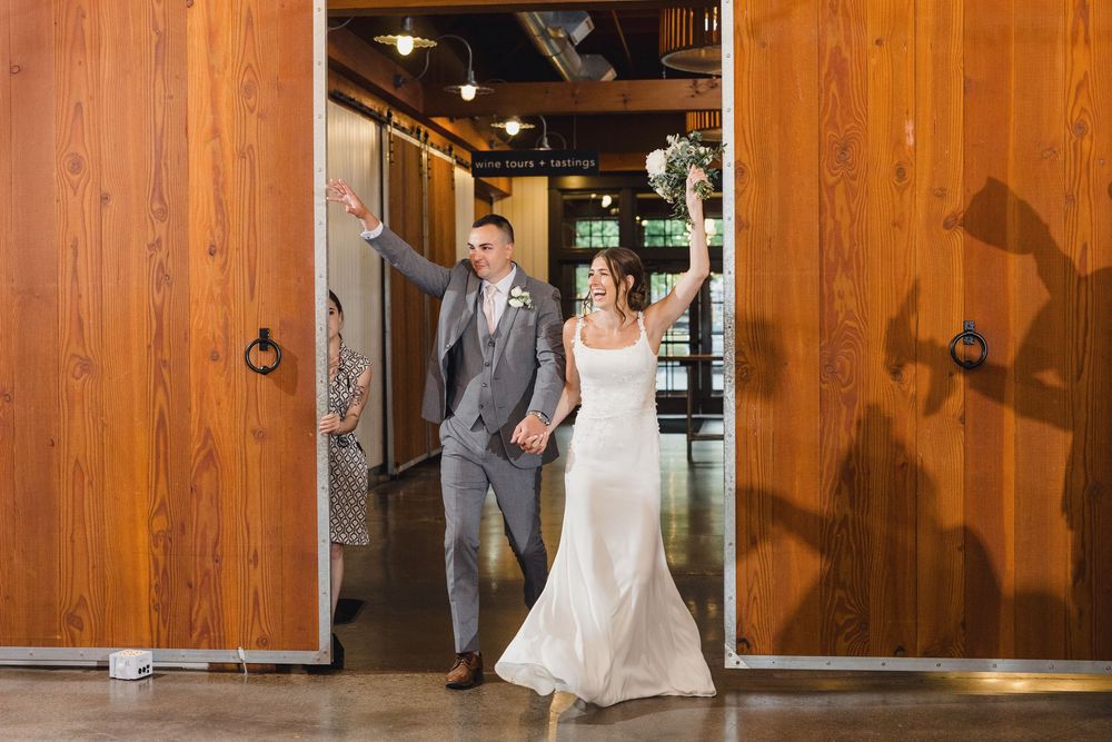 A couple shares a romantic moment in front of wooden barn doors at their wedding venue.