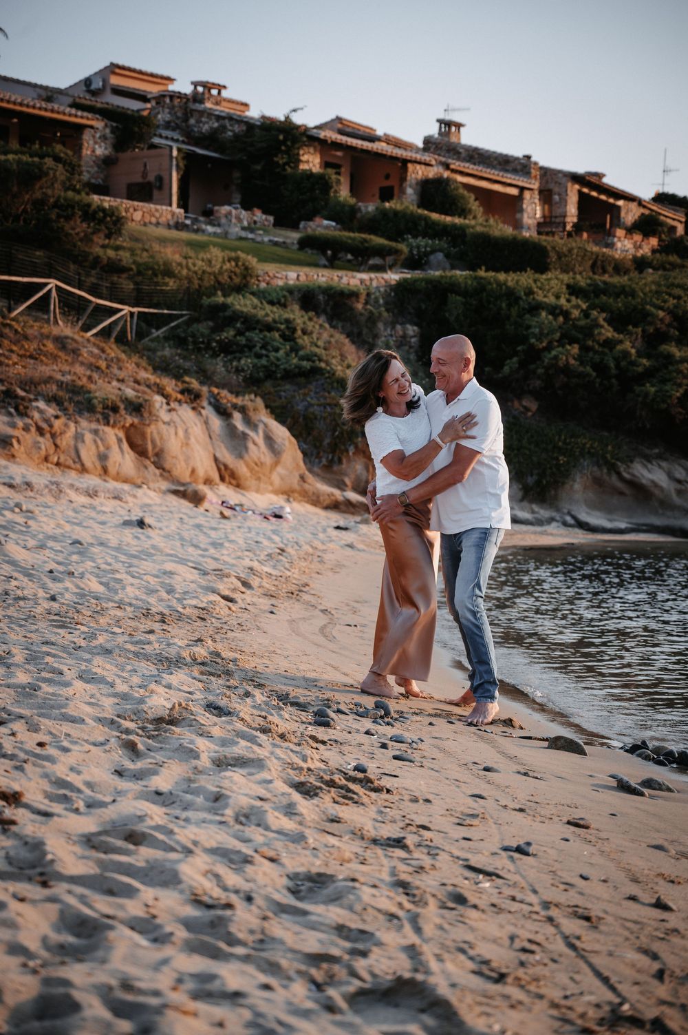 Paar läuft lachend am Strand entlang und albern gemeinsam im Sonnenuntergang