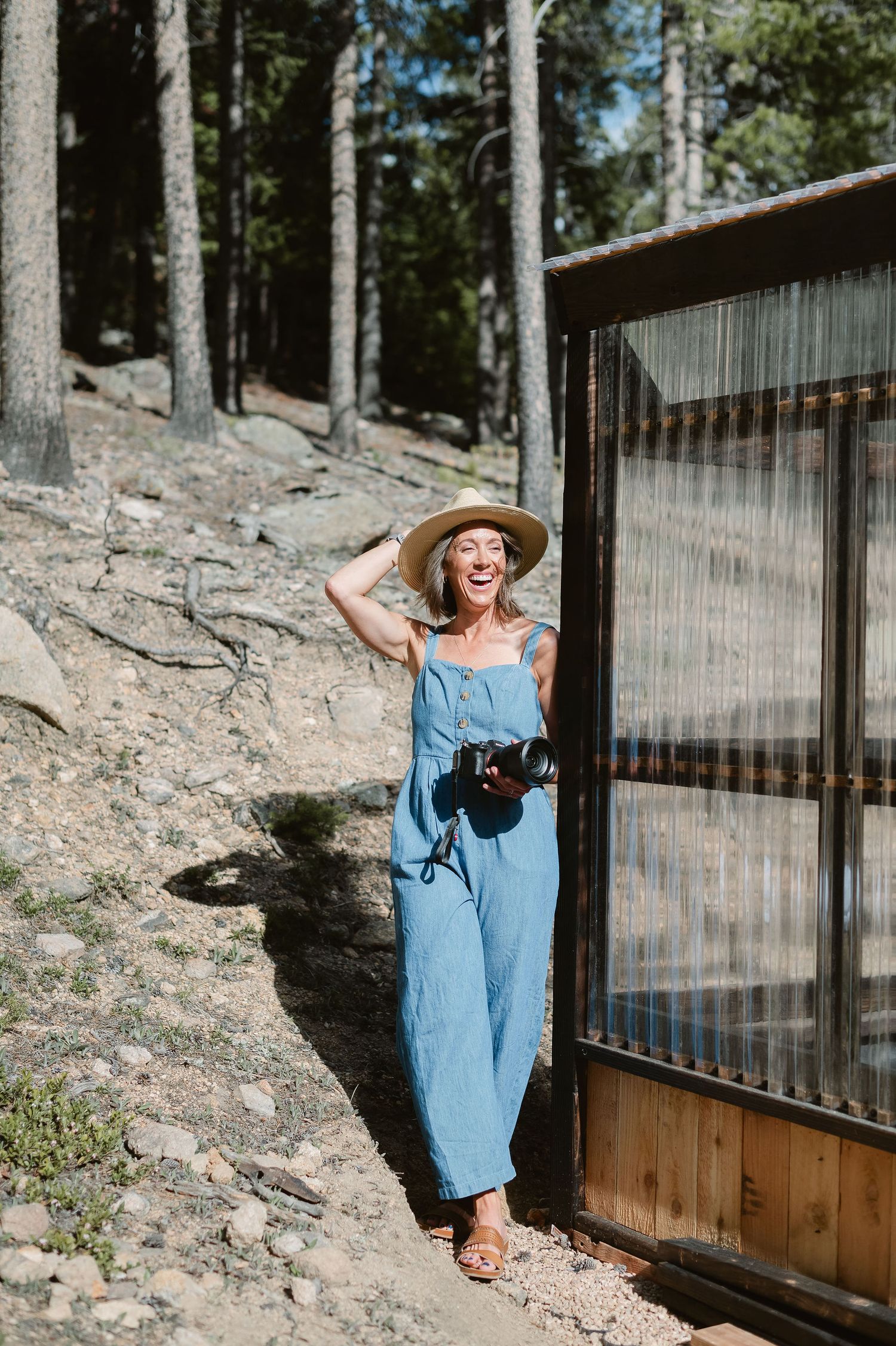 Colorado branding photographer laughing with camera in hand outdoors, natural and candid portrait