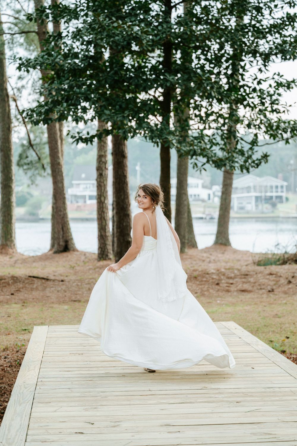 A sequence of photos showing a bride twirling in her white dress on a wooden dock surrounded by trees.