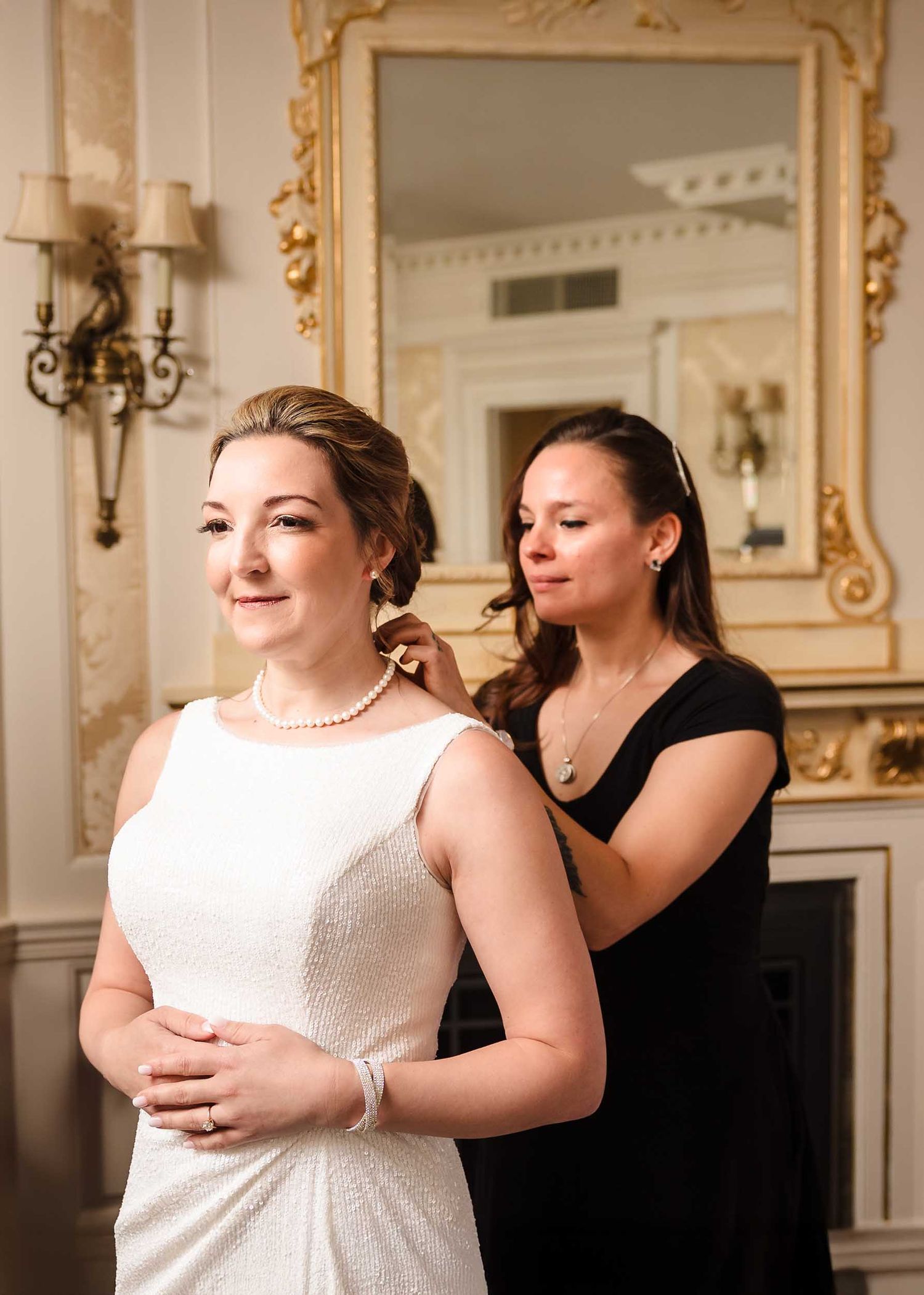 Bride getting ready in Judy Garland Suite at Lenox Hotel Boston putting on earrings in elegant room