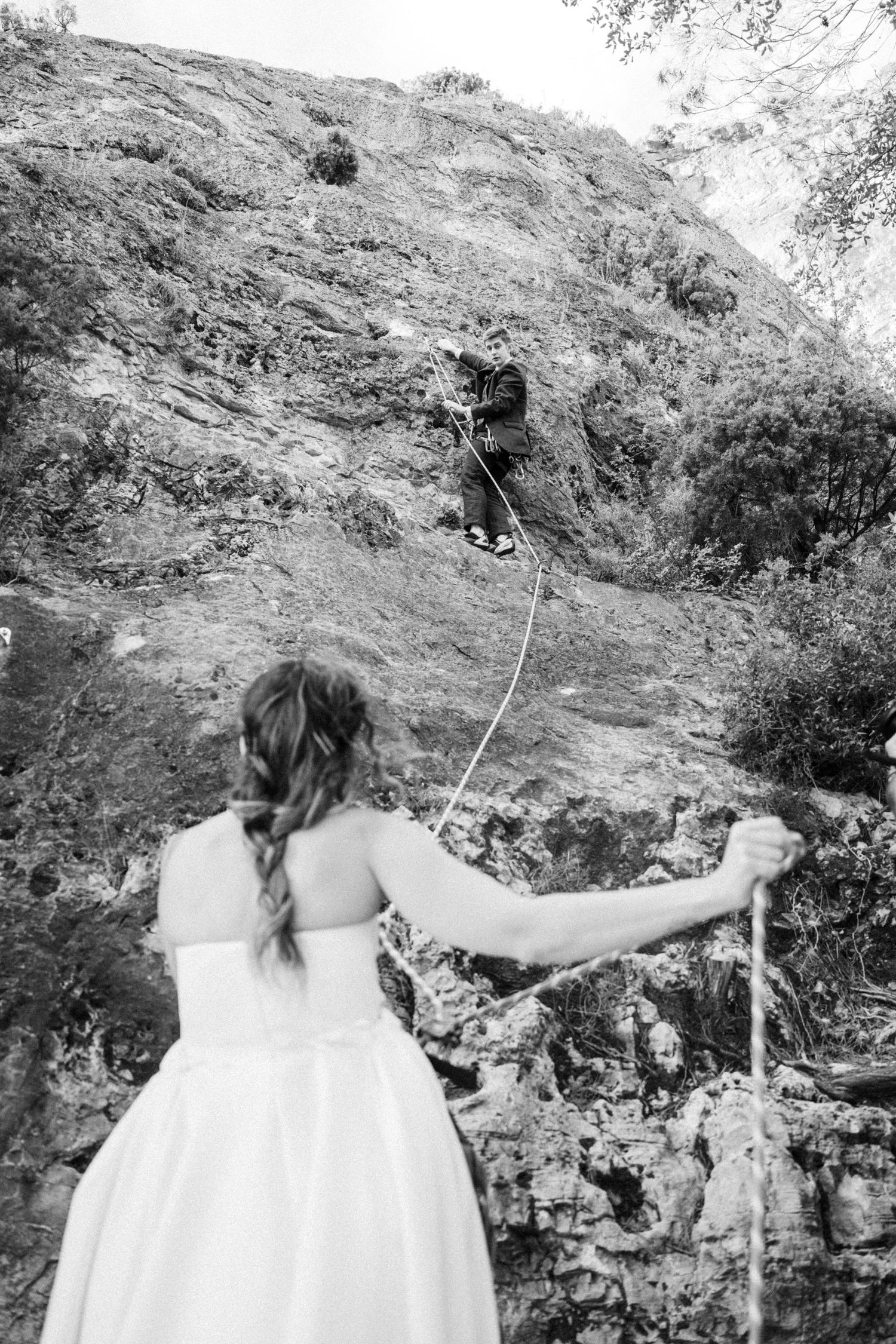 A sequence showing a person in a white dress climbing a rocky mountain face.