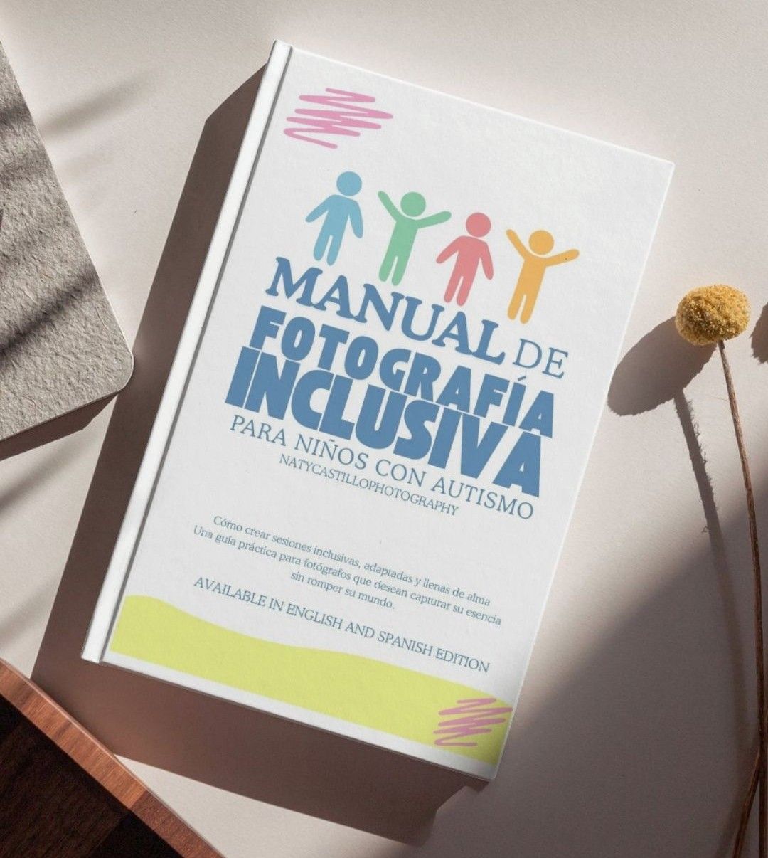 White book covers with colorful inclusive design elements and typography photographed from various angles on a light surface.