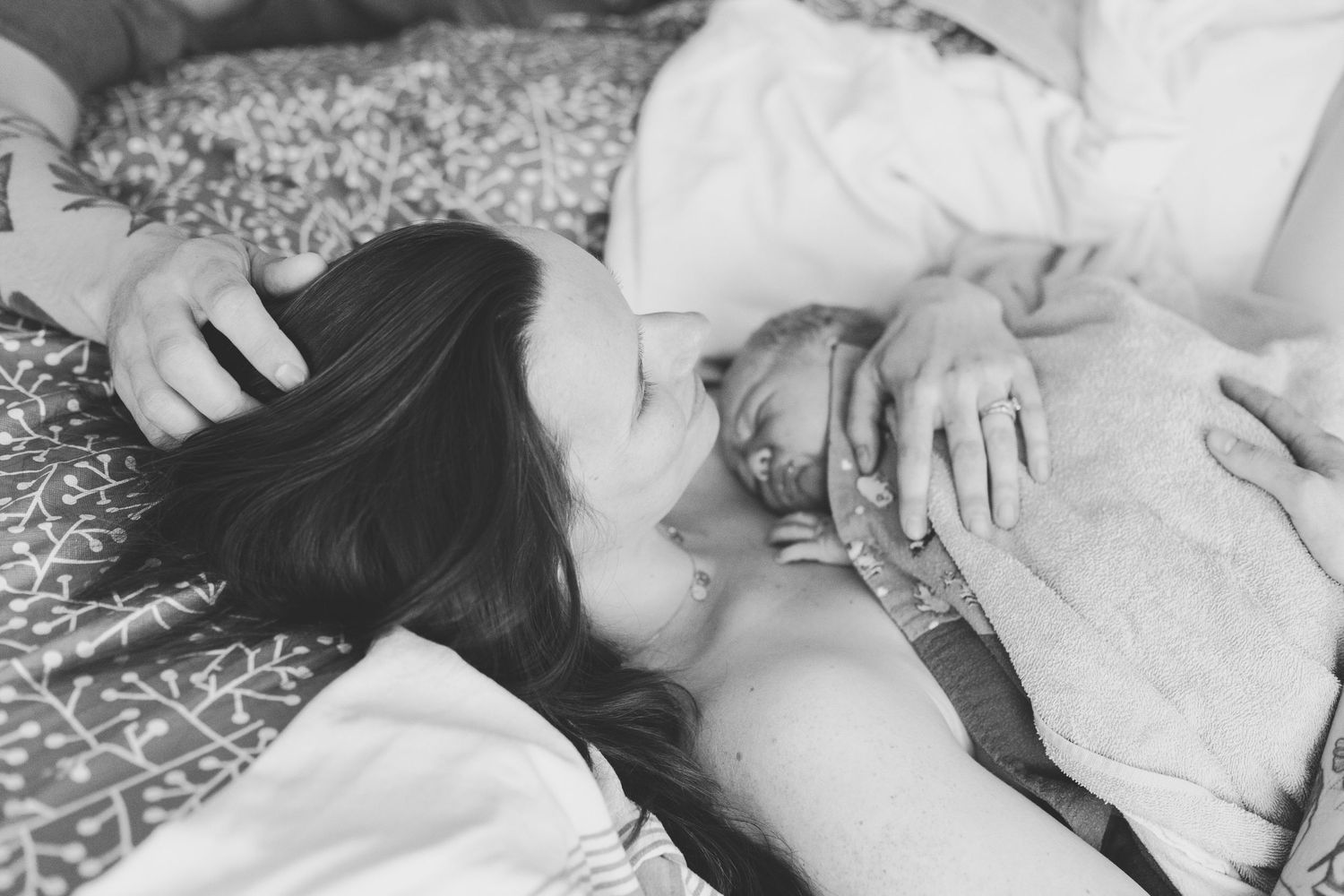 Beautiful glowing mother holding her newborn on her chest after birth.