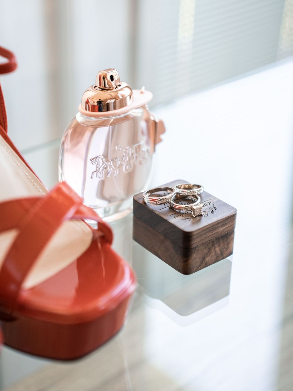 Wedding rings displayed on small geometric holders in a soft pink and coral color palette.